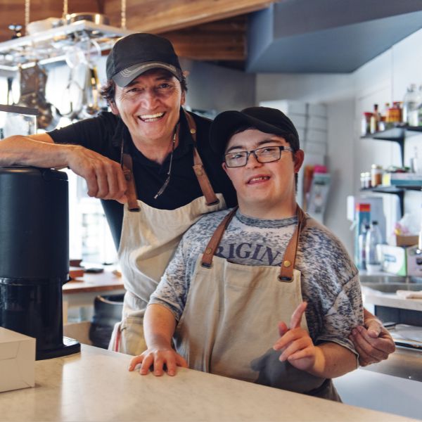 A disabled child next to his colleague at work